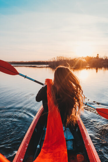 Femme pagayant dans un kayak sur le lac de Sidiailles au coucher du soleil