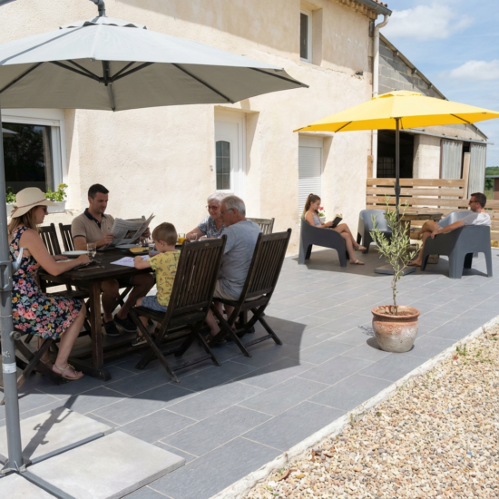 Terrasse du gîte avec table extérieure et espace détente, idéale pour repas en plein air dans le Cher